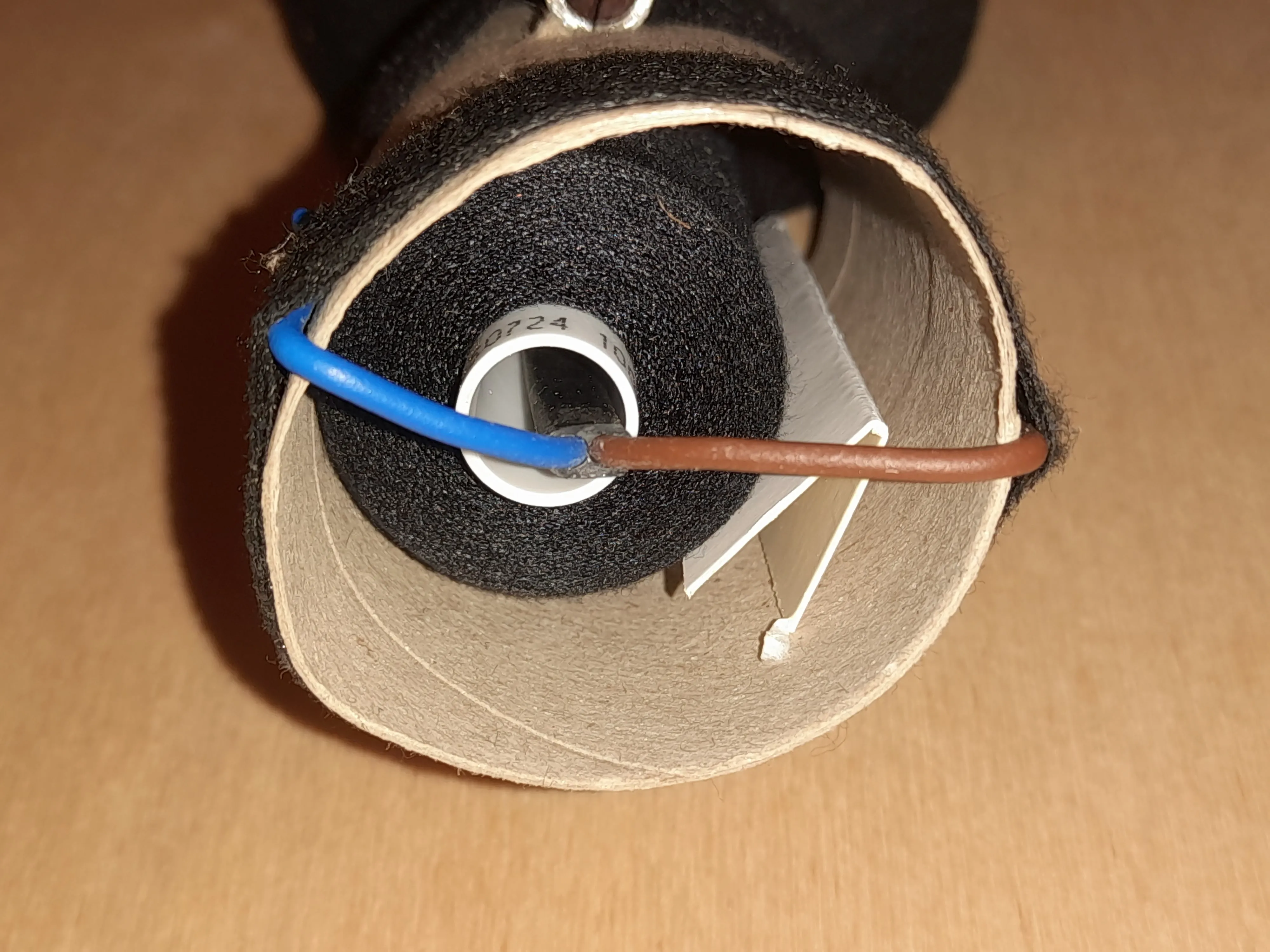 Cardboard brake inserted into the paper roll pressing against the spool