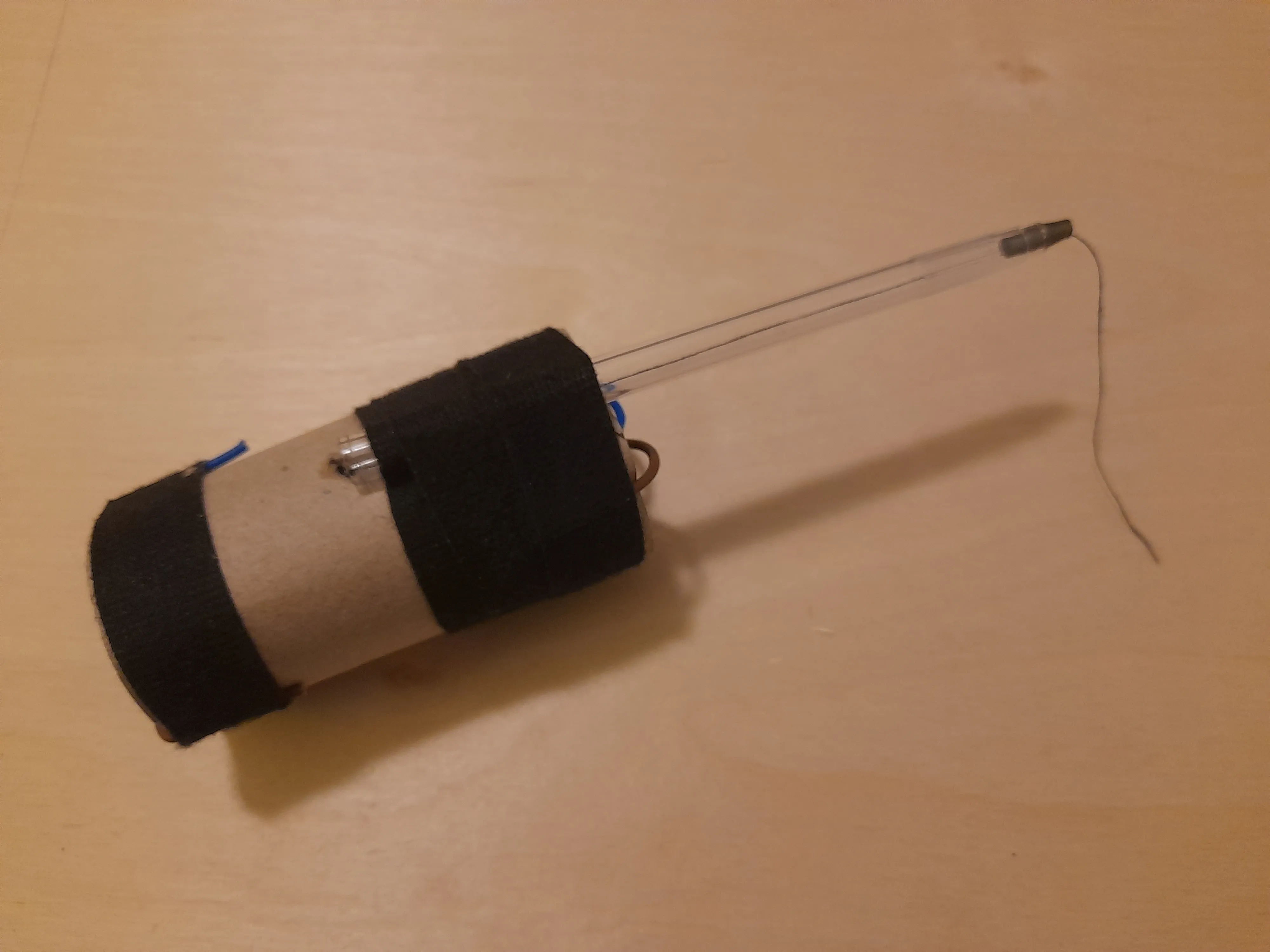 Pen barrel taped along the outside of the paper roll